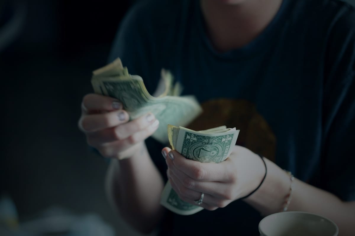 A person counting cash and budgeting